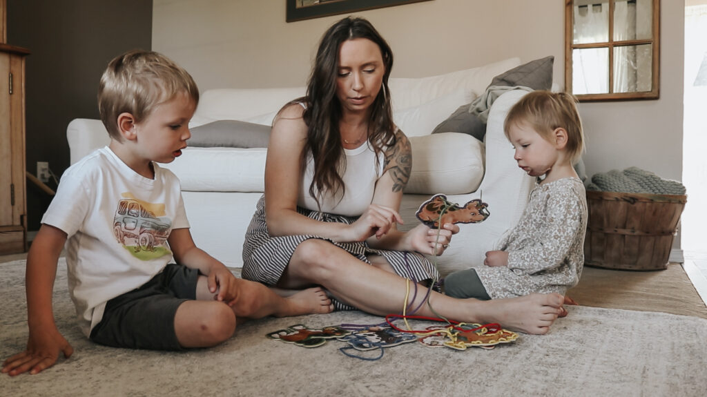 Christian homemaker plays games on the floor with her small children